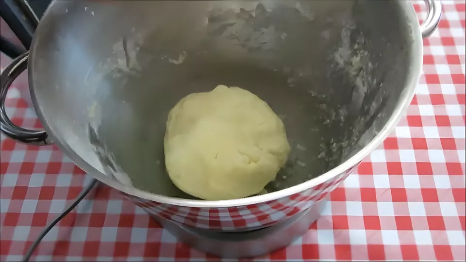 Smooth dough ball formed after kneading in the mixing bowl.