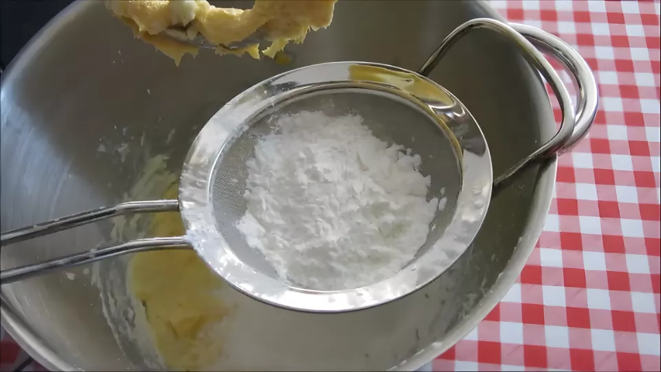 Sifting cornstarch and flour into the butter mixture.