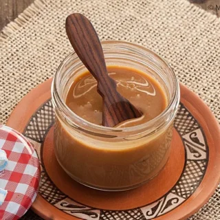 Jar of Traditional Dulce de Leche with a spoon.