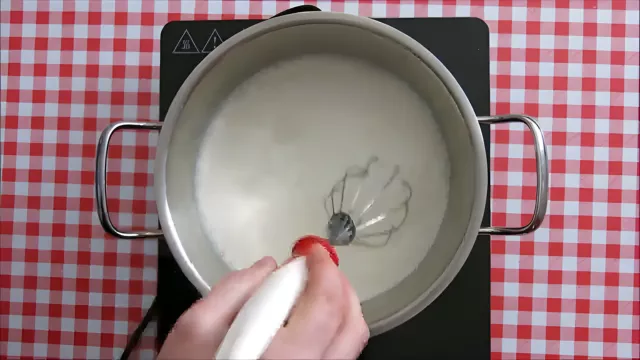 Whisking milk and sugar in a pot to start making Traditional Dulce de Leche.