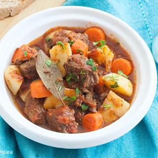 Beef stew served with bread on the side.