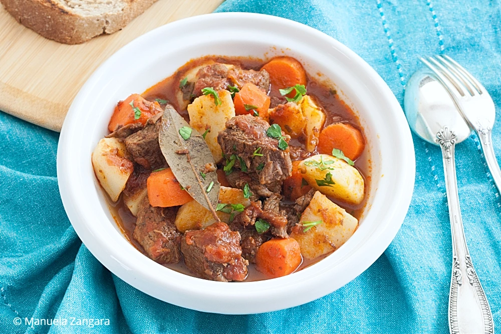 Beef stew served with bread on the side.