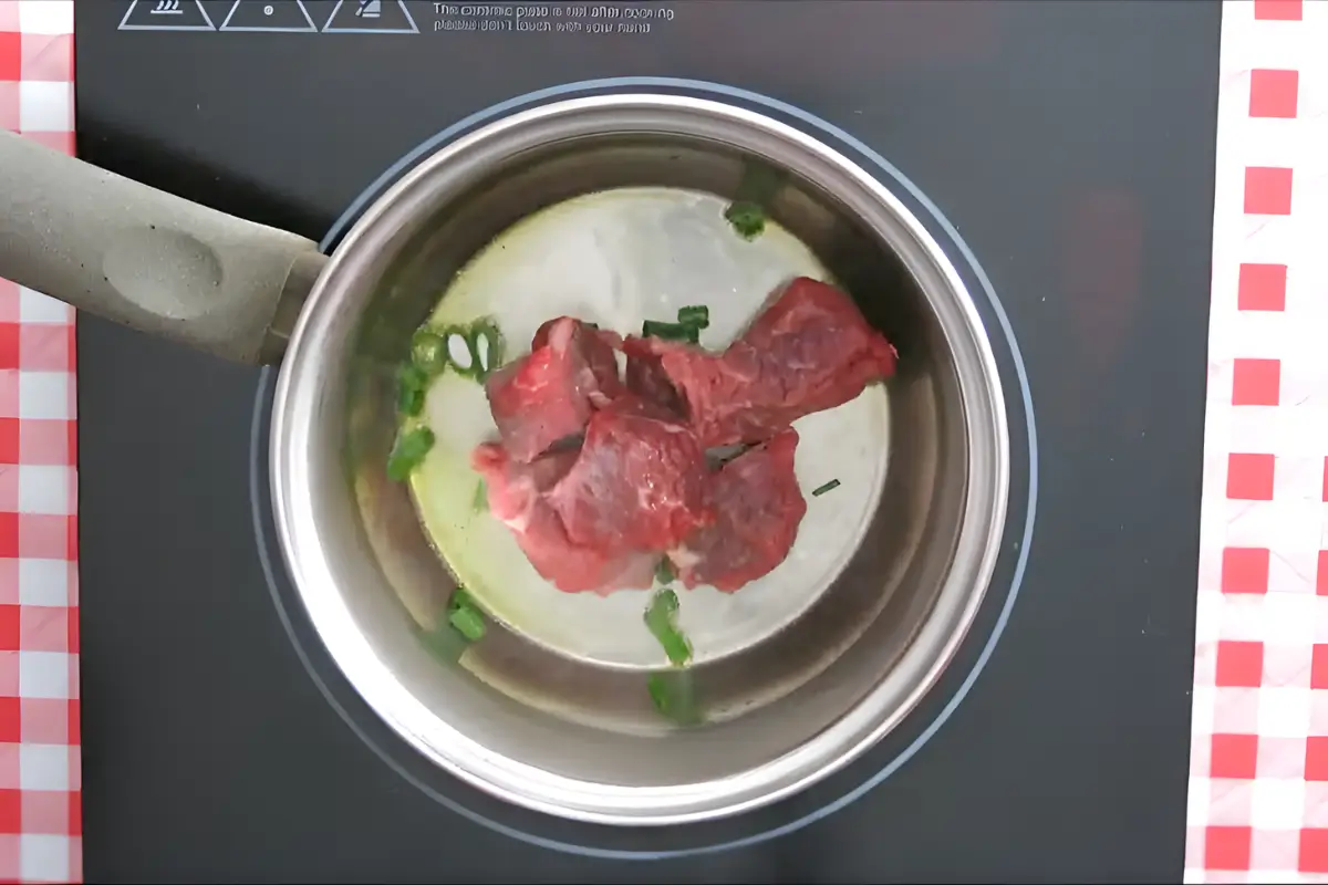 Beef pieces browning in a pot.