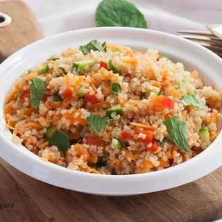 Detailed view of quinoa mixed with carrot, cucumber and fresh mint.