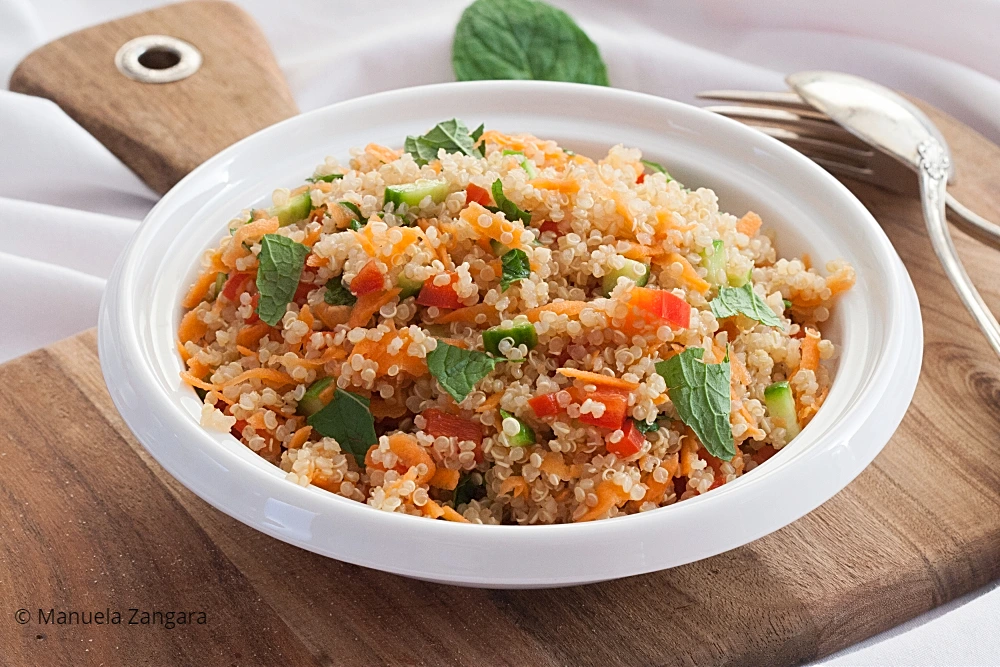 Detailed view of quinoa mixed with carrot, cucumber and fresh mint.