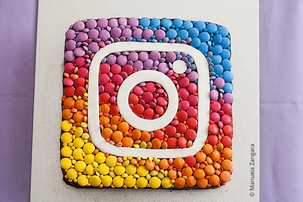 Instagram Cake covered with colourful chocolate candies and fondant logo.