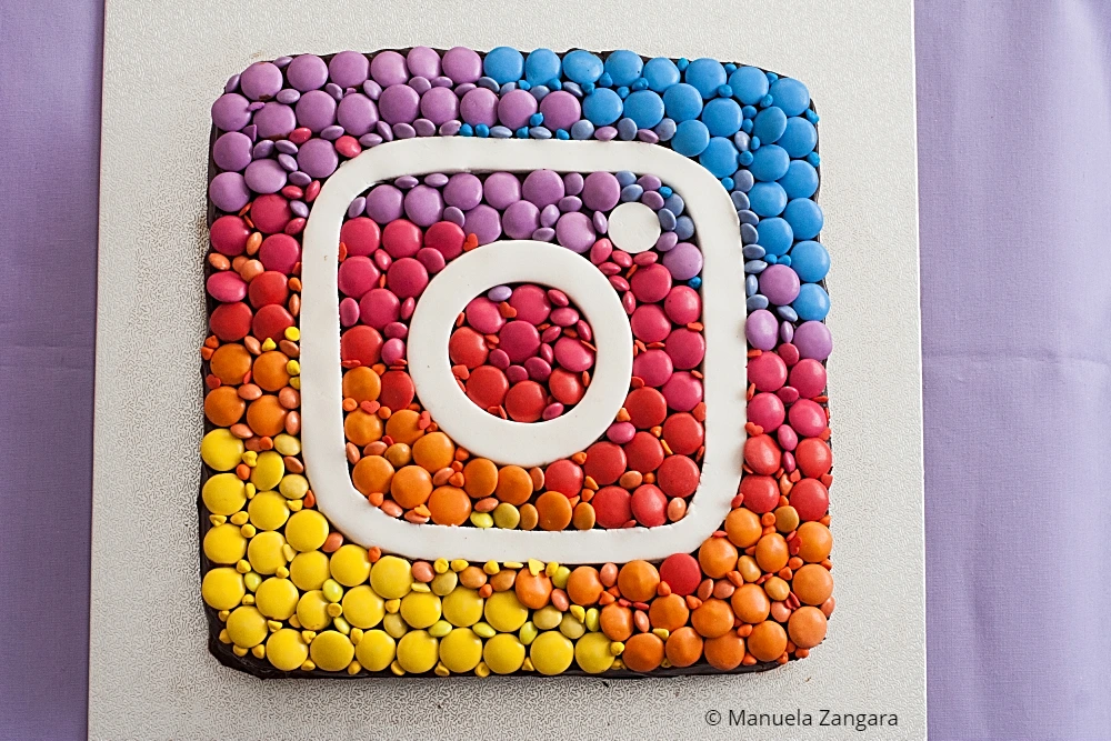 Decorated Instagram Cake with coloured chocolates arranged in sections.