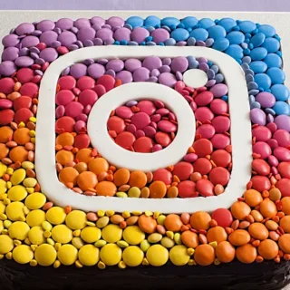 Finished Instagram Cake decorated with coloured chocolates and fondant logo.
