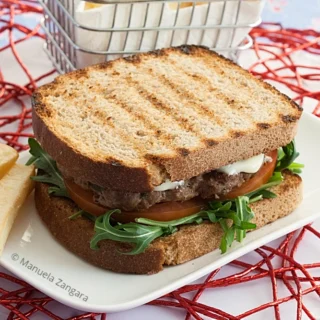 Low FODMAP Beef Burger served on toasted sourdough with rocket, tomato and fries.