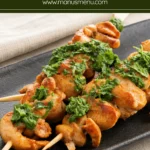 Juicy grilled chicken skewers with fresh herb sauce served on a platter.