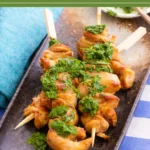 Grilled chicken skewers topped with fresh herb sauce.