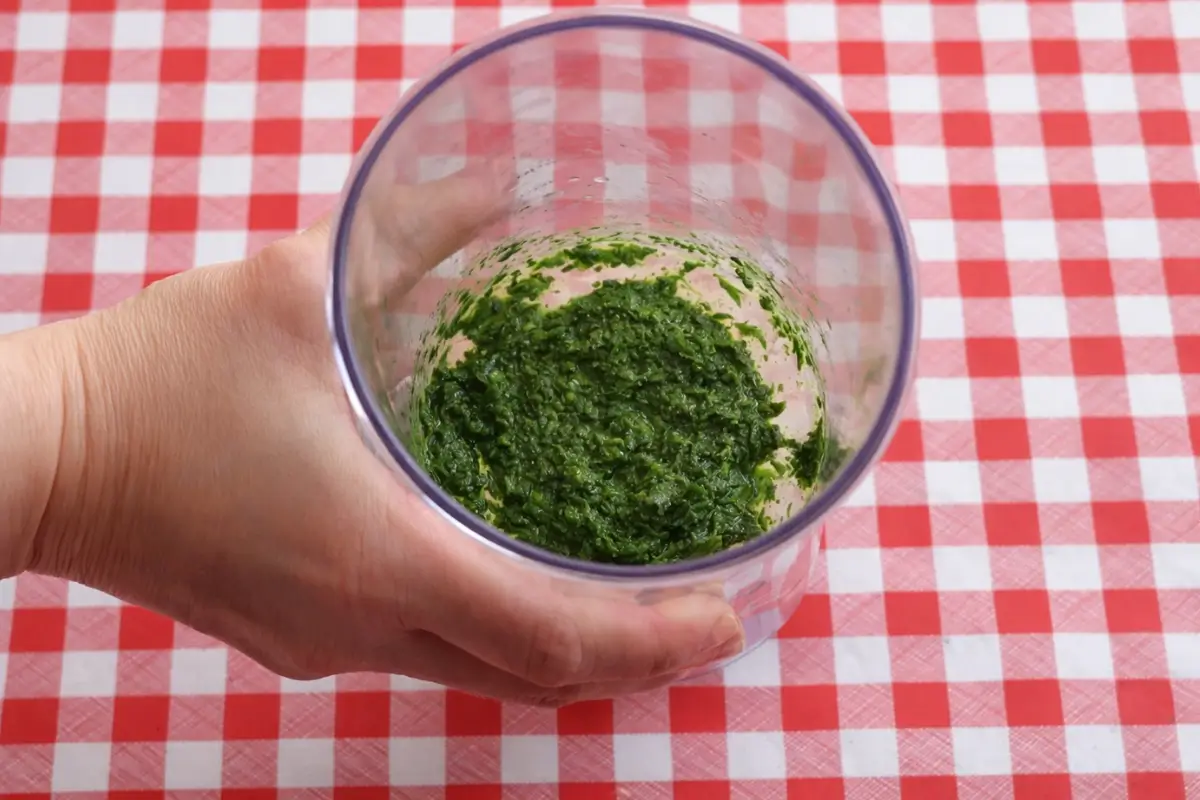 Fresh herb sauce blended until smooth in a container.