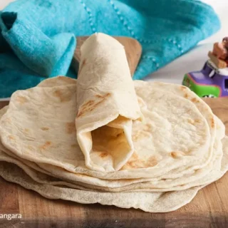 Folded tortilla showing pliable texture with teal napkin.