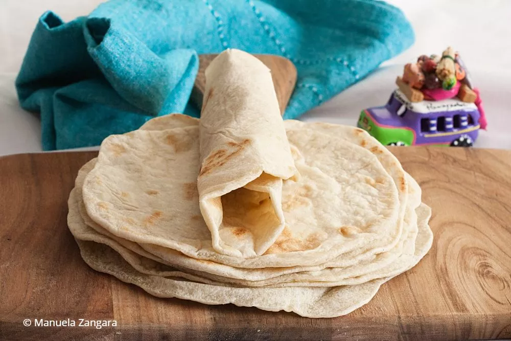 Folded tortilla showing pliable texture with teal napkin.