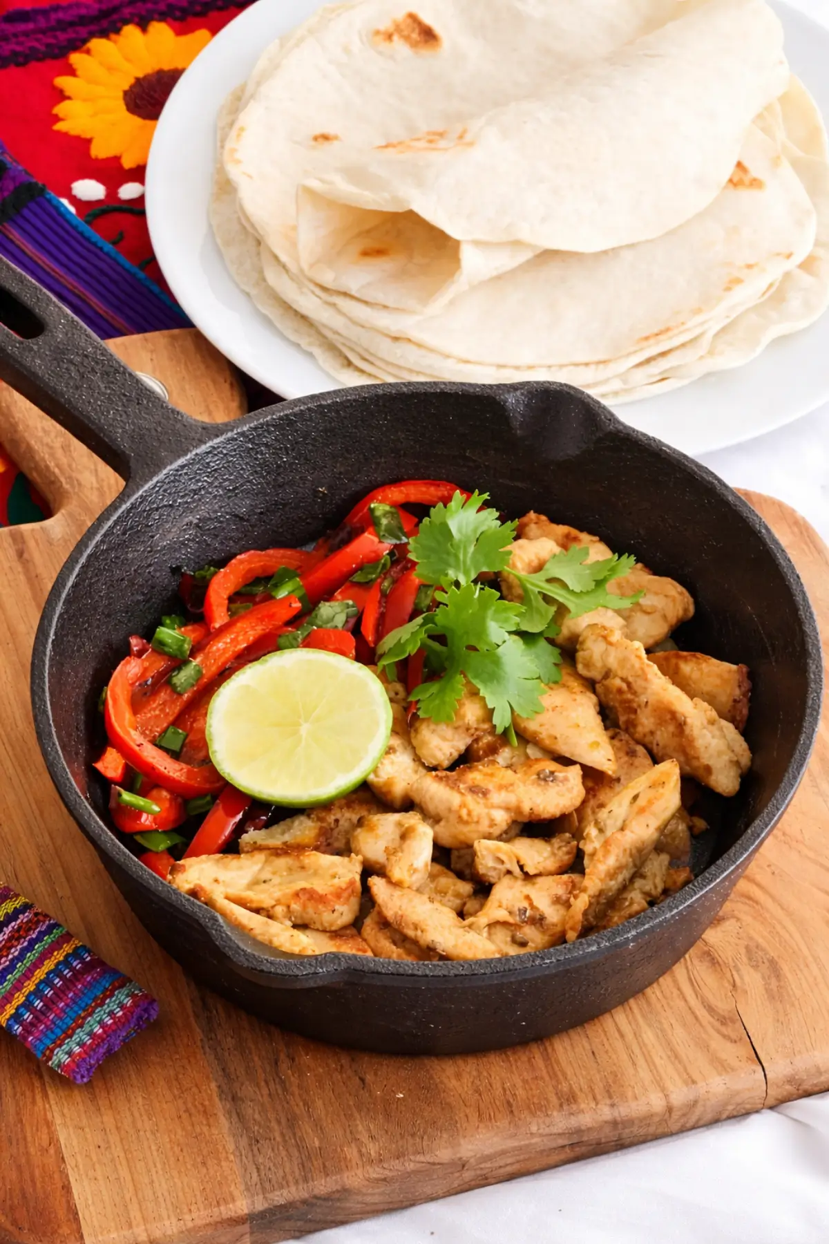 Chicken fajitas topped with fresh coriander and lime.