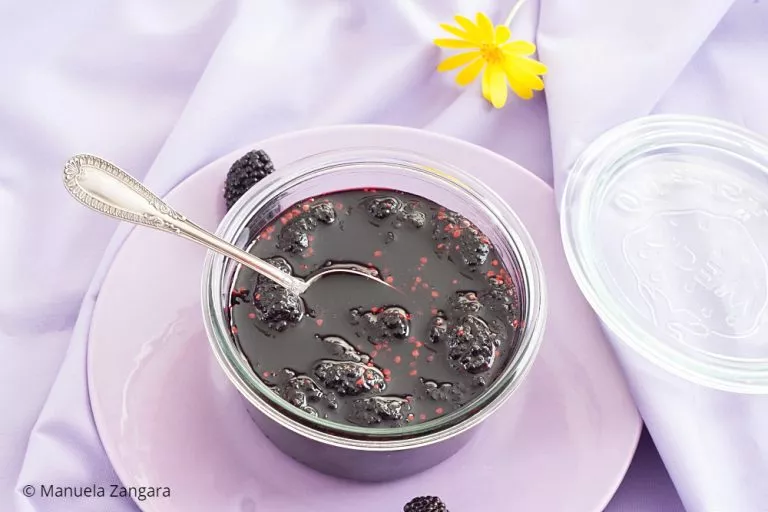 Mulberry jam in a clear bowl with visible whole berries.
