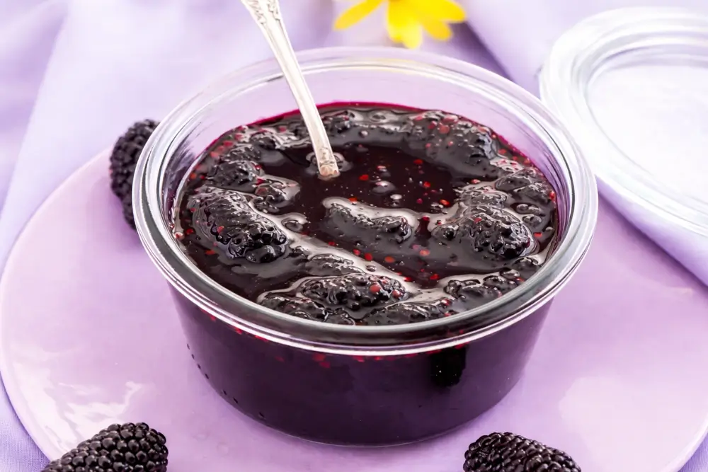 Homemade mulberry jam stored in a clear glass jar.