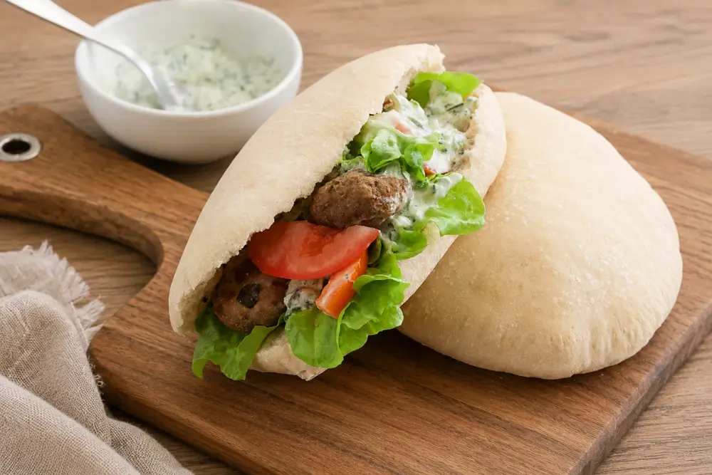 Warm pita filled with seasoned pork meatballs, fresh lettuce, tomatoes and tzatziki.