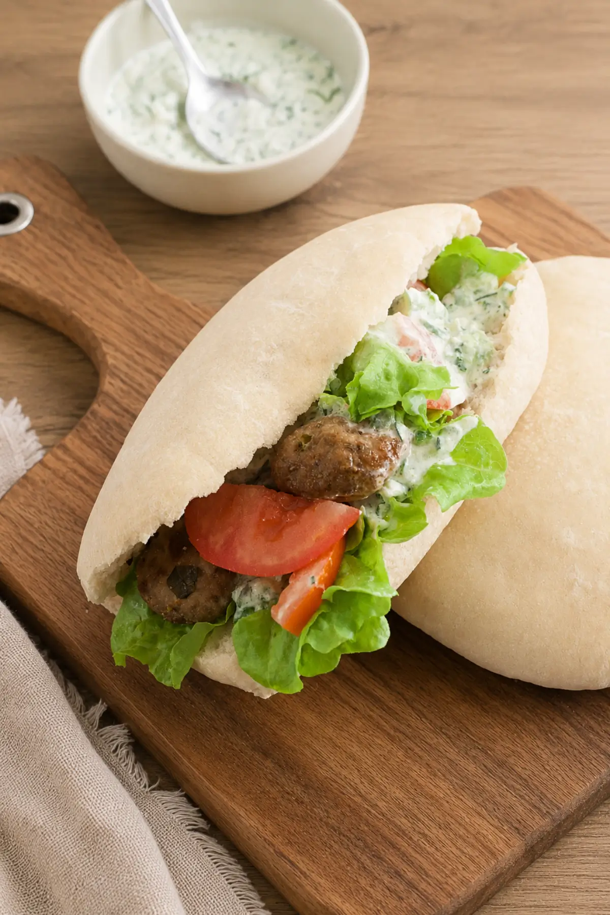 Pork gyros filled with juicy meatballs, crisp lettuce, sliced tomatoes and creamy tzatziki.