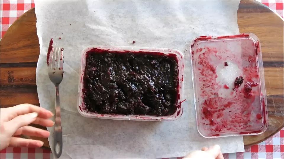 Frozen mulberry mixture being scraped with a fork to create a sorbet-like texture.