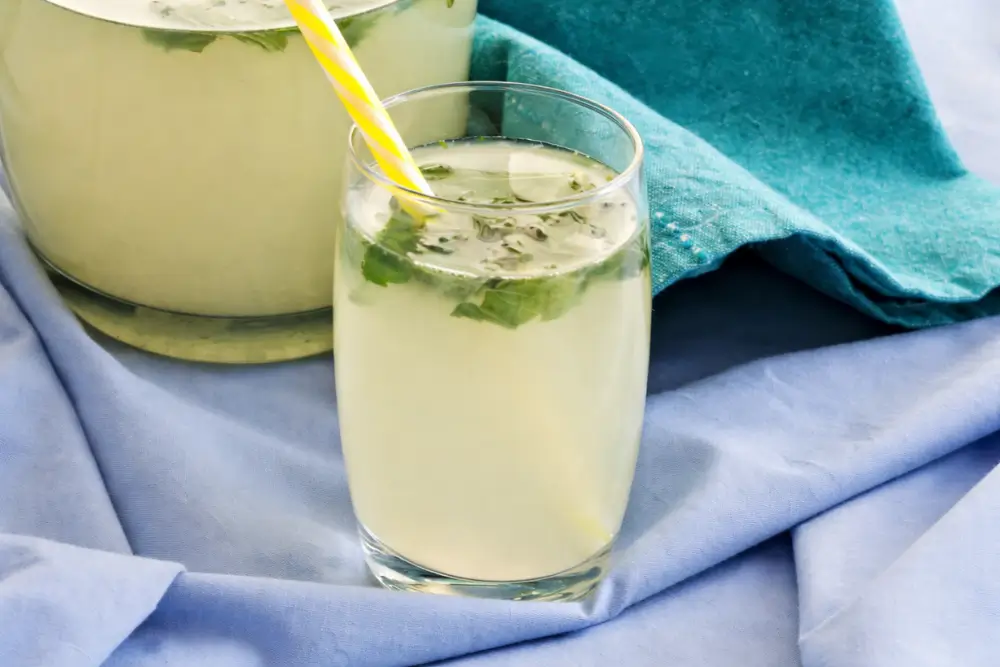 Chilled mint lemonade with chopped mint leaves served in a clear glass.