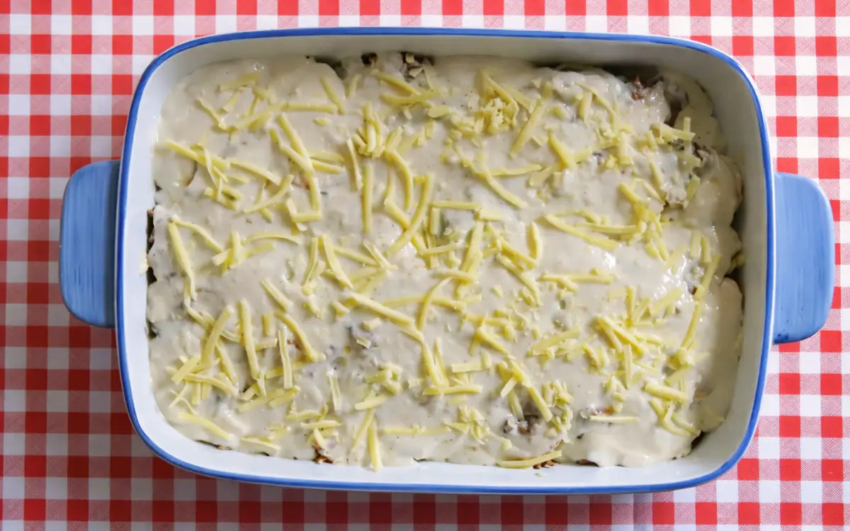 Baking dish layered with vegetables and meat sauce covered in béchamel and grated cheese.