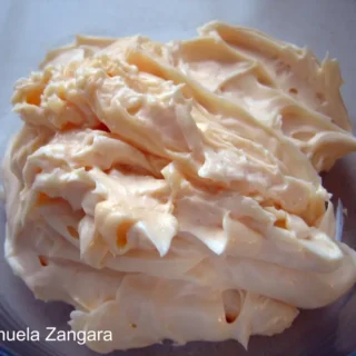 Close-up of thick, creamy homemade mayonnaise in a glass bowl.