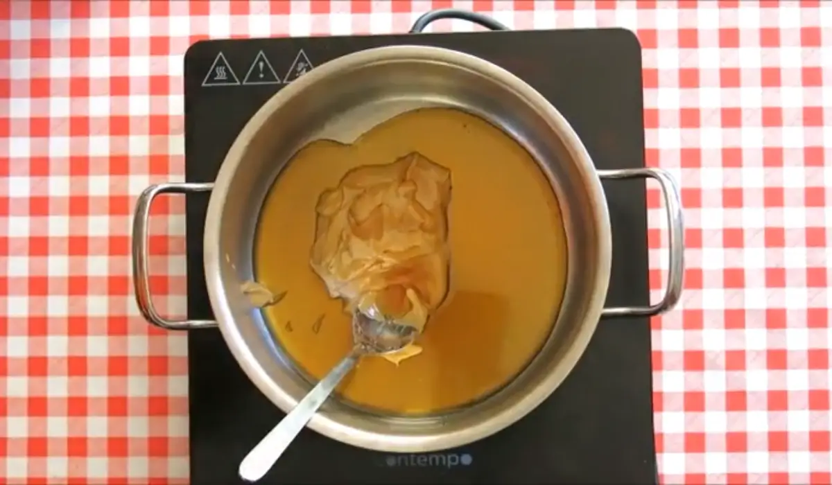 Peanut butter melting with maple syrup in a saucepan.