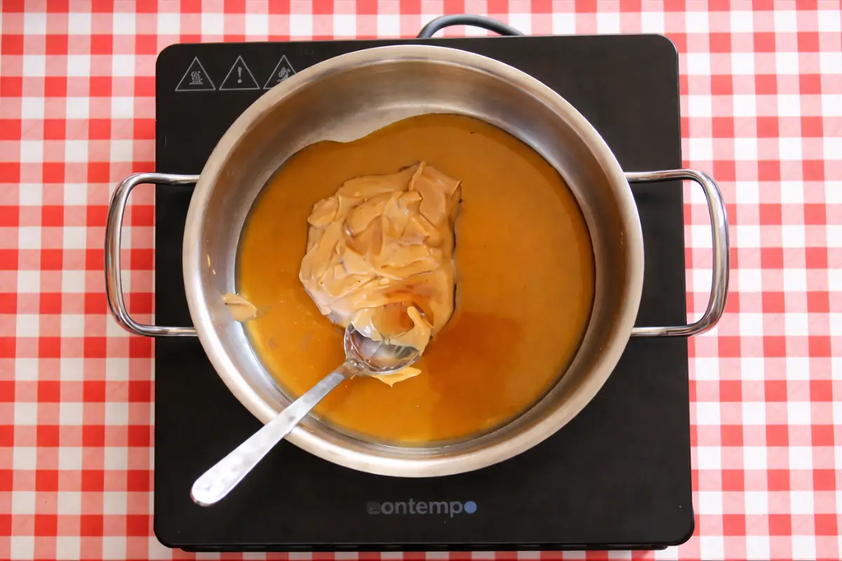 Peanut butter and maple syrup melting together in a saucepan for low fodmap bars.
