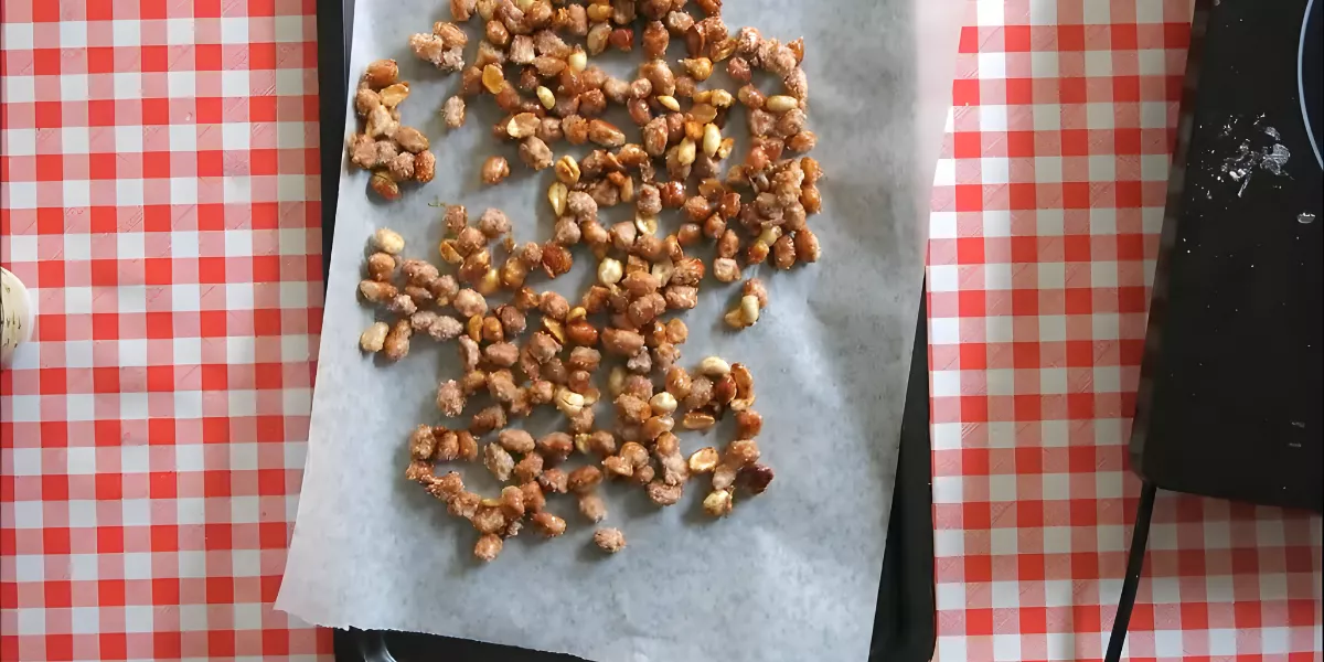 Caramelised peanuts spread on baking paper to cool and harden.