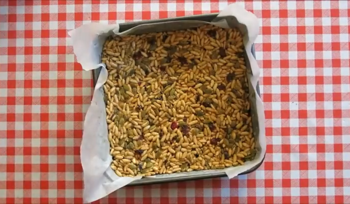 No-bake bar mixture pressed evenly into a lined baking tray.