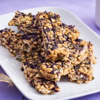 Close-up of sliced low fodmap protein bars showing puffed rice, seeds, and chocolate drizzle.