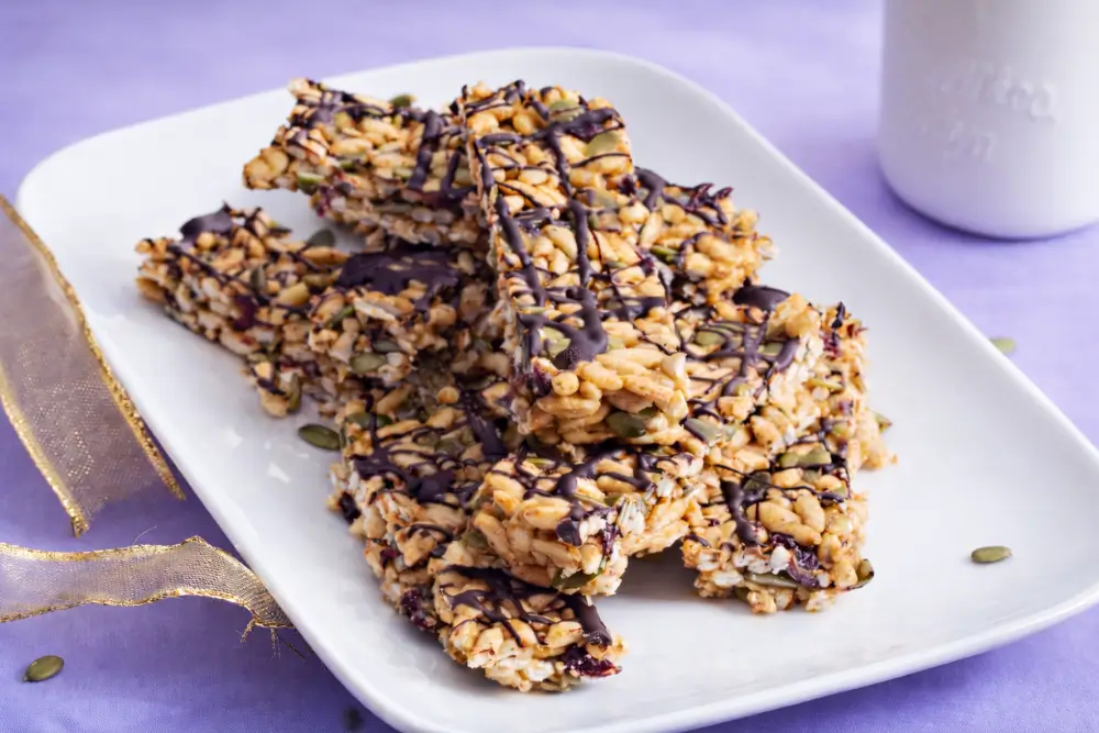 Close-up of sliced low fodmap protein bars showing puffed rice, seeds, and chocolate drizzle.