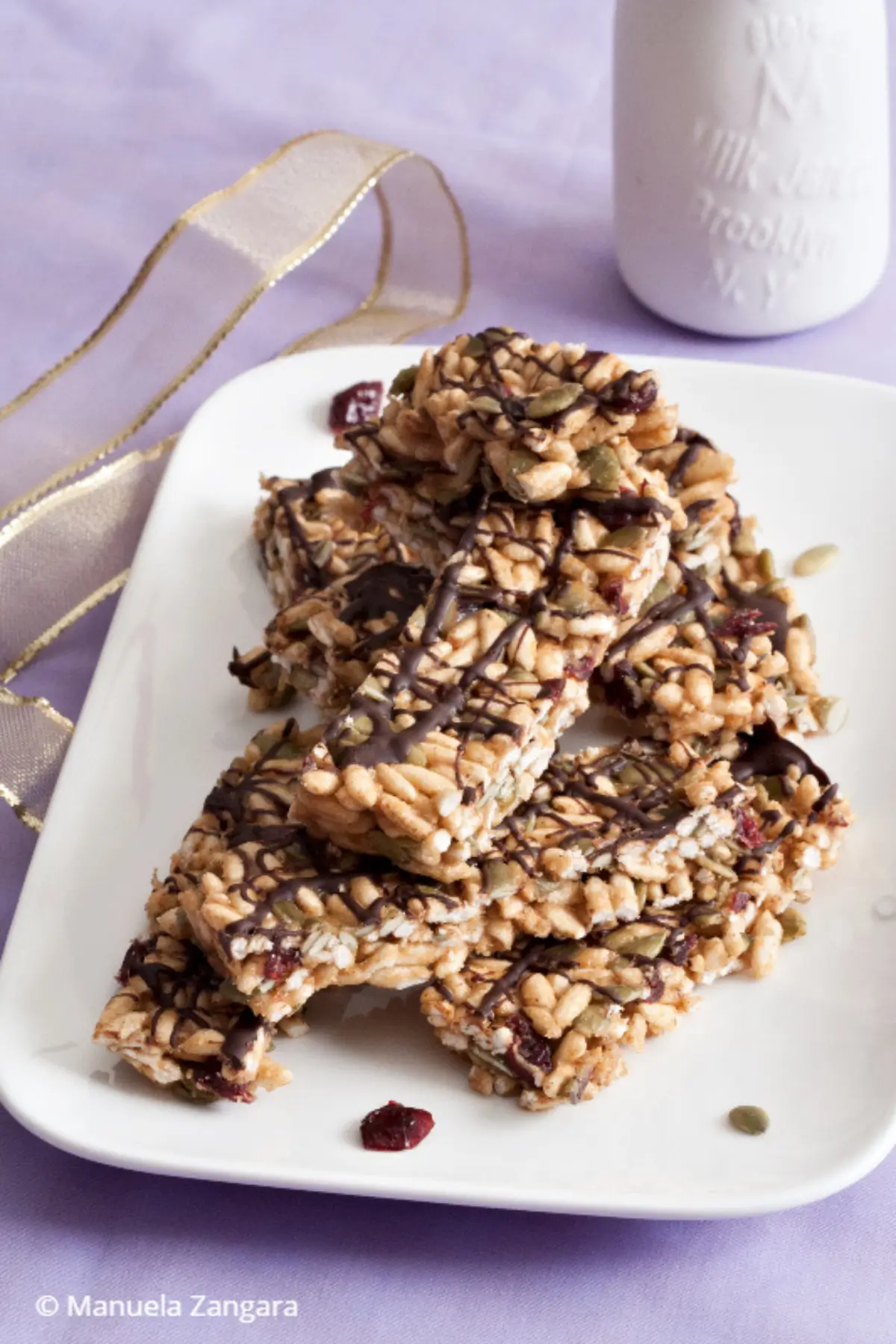 Energy bars stacked with visible seeds and chocolate drizzle,