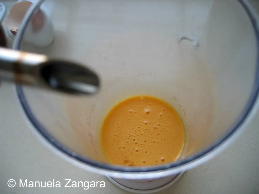 Oil being added drop by drop to egg yolks while whisking.