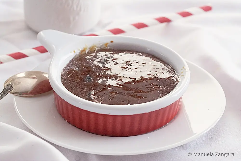 Chocolate Crema Catalana with a glossy caramelised sugar crust in a red ramekin.