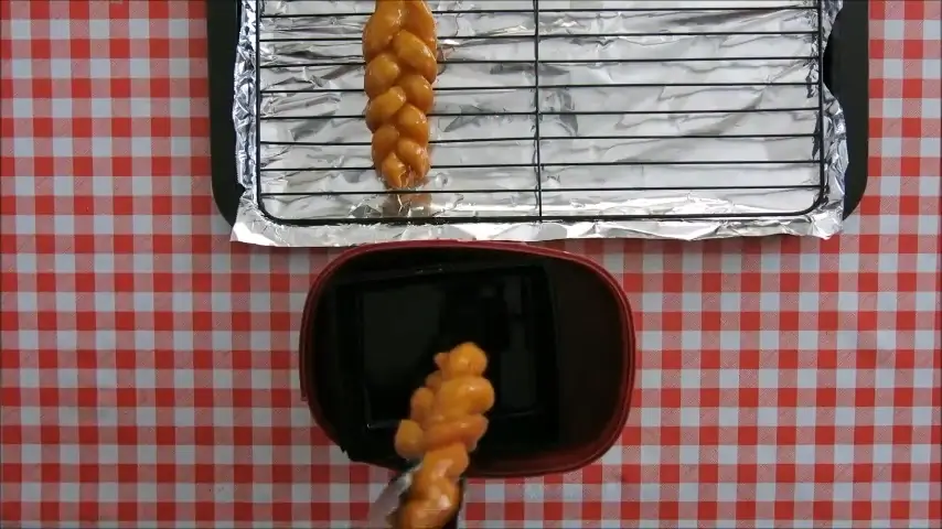 Cooling syrup-dipped koeksisters arranged neatly on a rack.