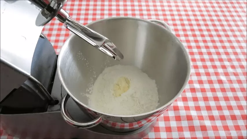 Mixing flour and margarine in a bowl to prepare the dough for easy koeksisters recipe.