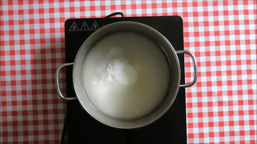 Water, sugar, and cream of tartar simmering in a saucepan to make syrup for traditional South African koeksisters.
