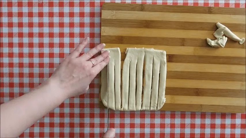 Cutting koeksisters dough strips lengthways before braiding.