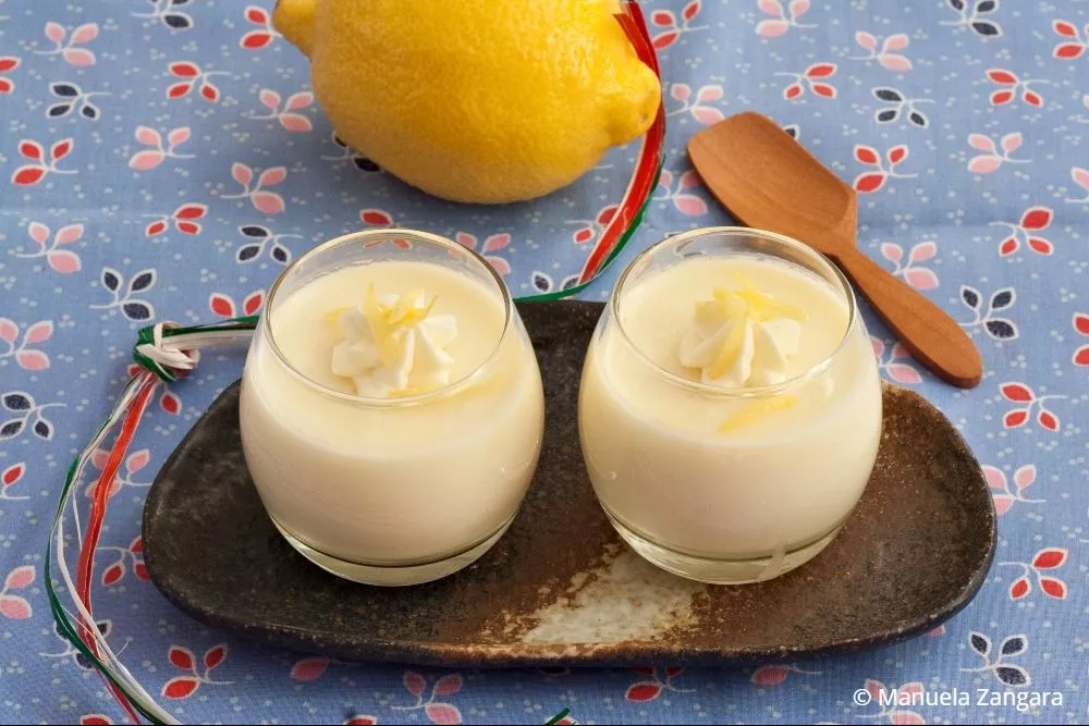 Best Lemon Panna Cotta recipe served in glass cups with fresh lemon and wooden spoon.