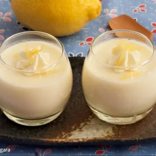 Close-up of creamy Panna Cotta with lemon zest and whipped cream topping.