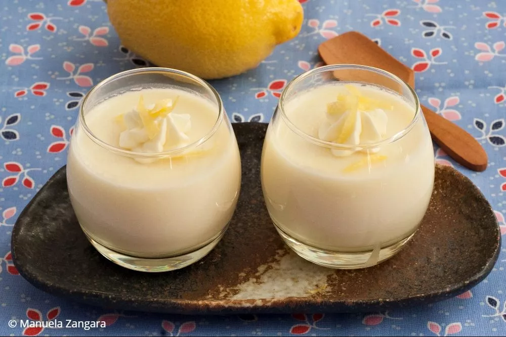 Close-up of creamy Panna Cotta with lemon zest and whipped cream topping.