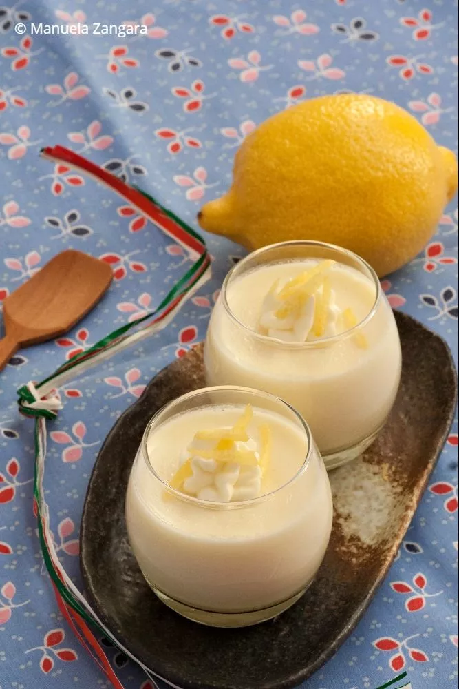Two glasses of easy Lemon Panna Cotta dessert with whipped cream and lemon garnish.