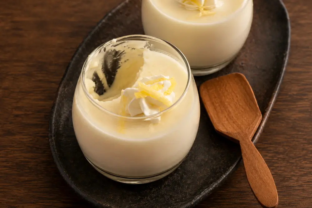 Creamy dessert with a spoonful removed beside a second glass.