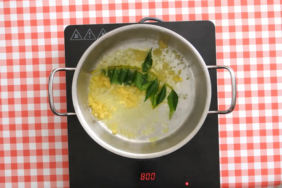 Chopped garlic and curry leaves sizzling gently in oil.