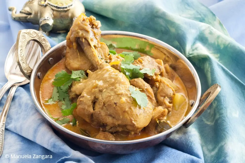 Low FODMAP chicken curry served with potatoes and coriander.