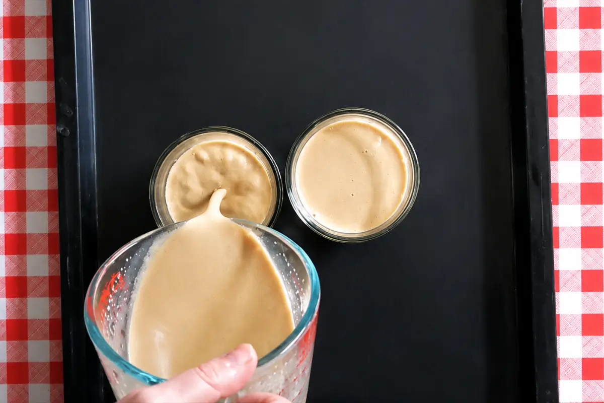 Coffee cream mixture being poured into serving glasses to set.