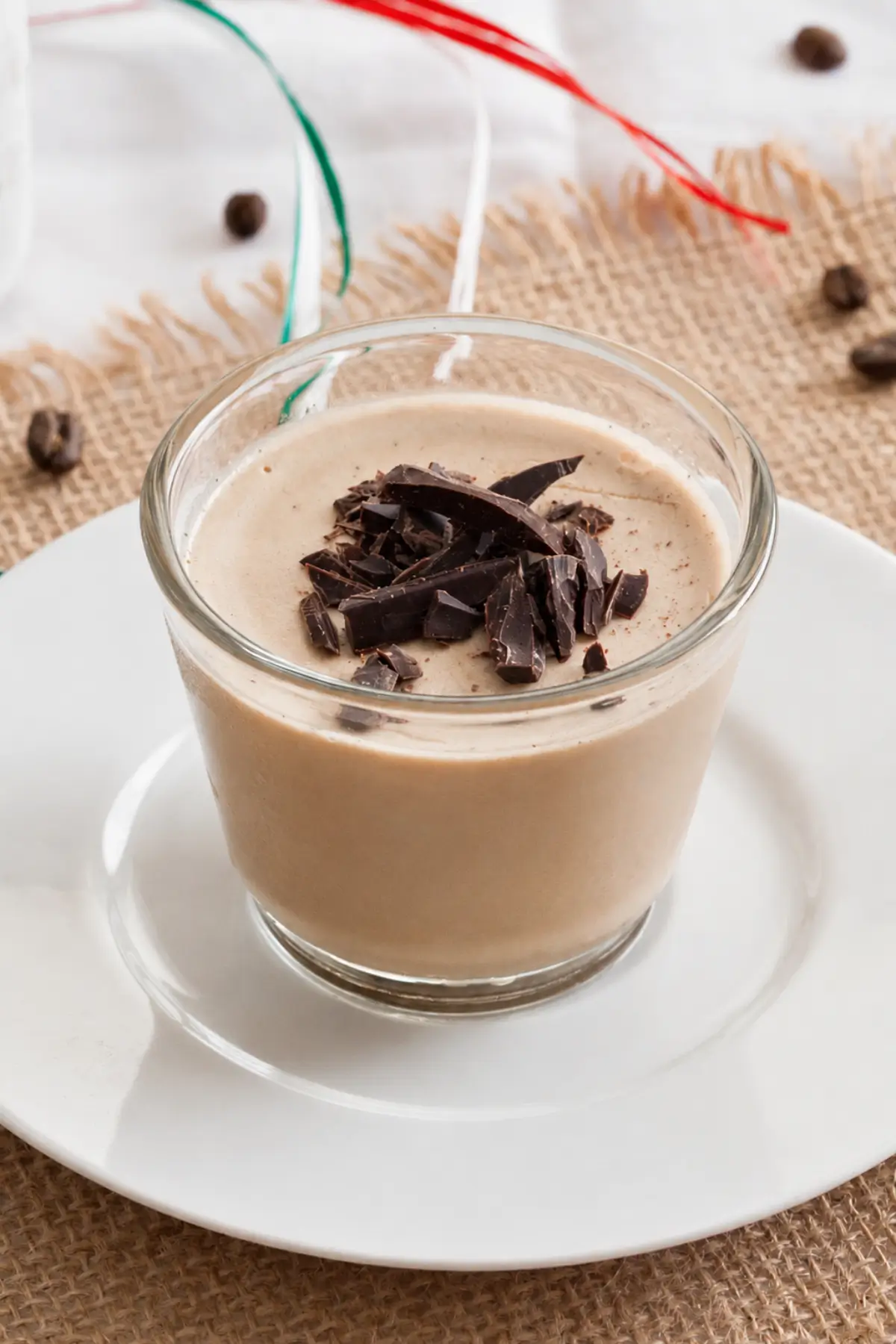 Espresso panna cotta served in a glass with chocolate shavings.