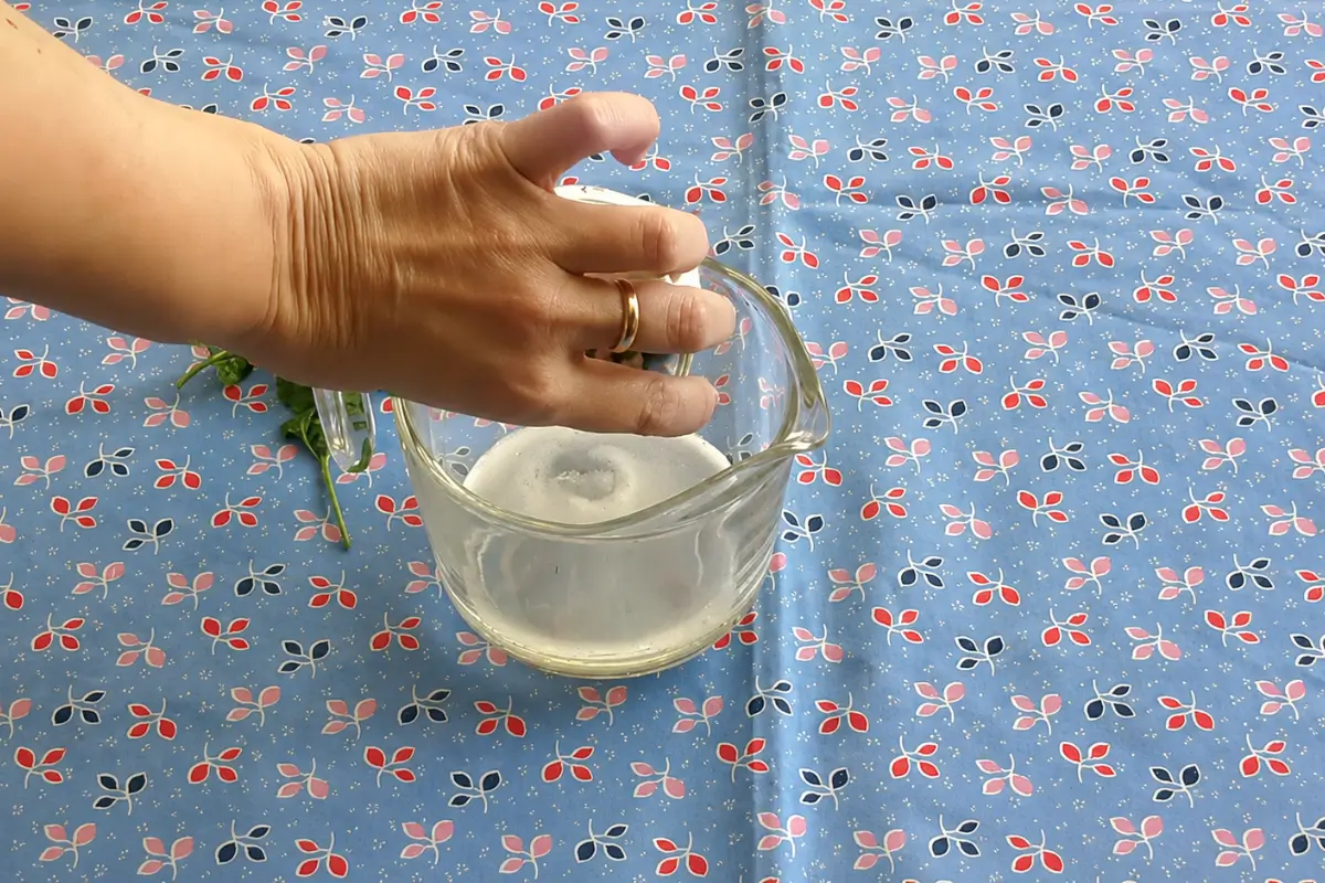 Hand stirring Prosecco and elderflower syrup together before assembling the cocktail.